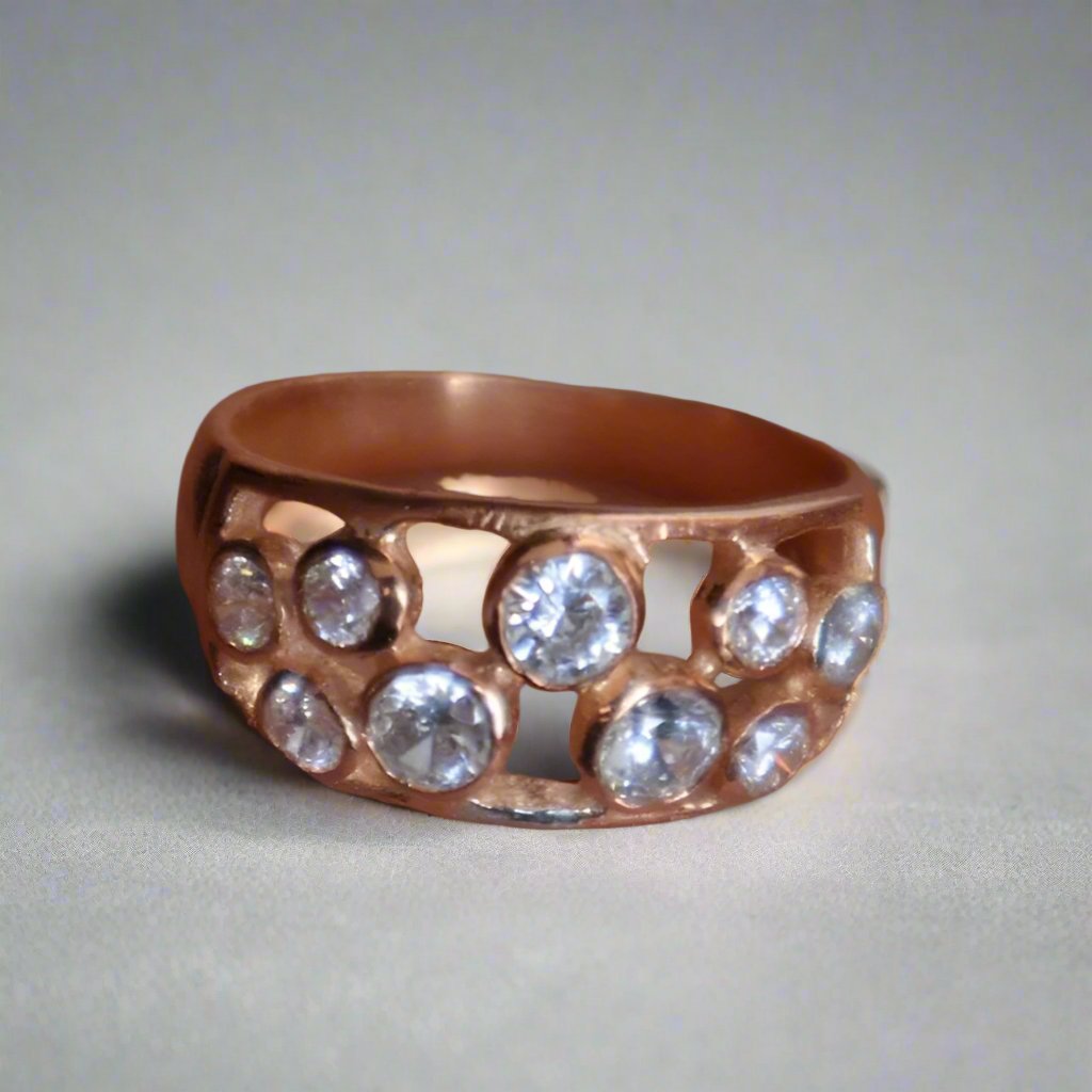 A rose gold ring adorned with several small, round diamonds held in an openwork design.