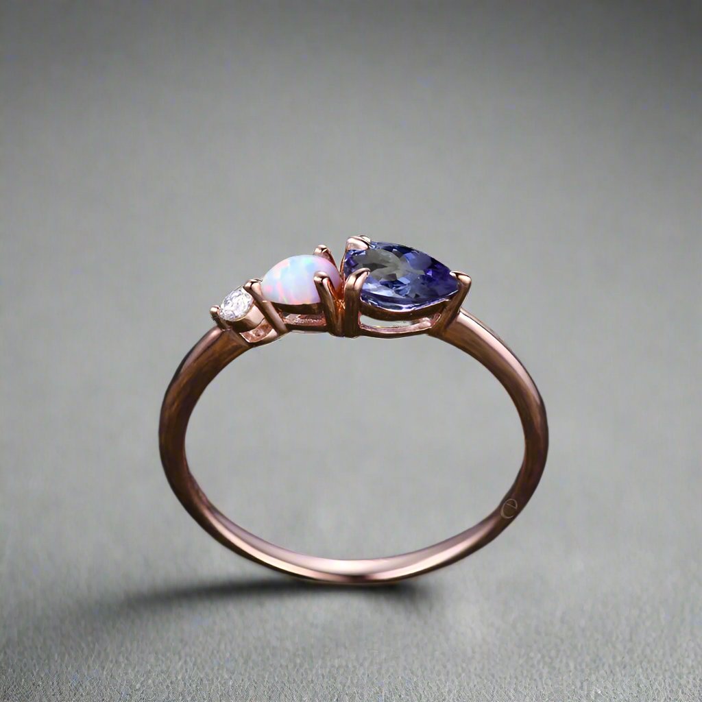 Ring adorned with a Tanzanite opal and white opal, set in rose gold, enhanced by ta moissanite. 