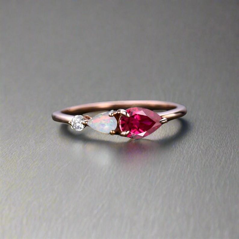 Ruby stone ring featuring two opal and diamonds, elegantly designed for a sophisticated look.