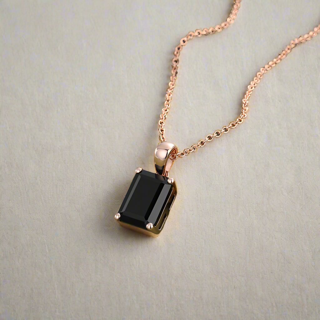 Emerald-cut black onyx pendant with 6x8mm centerpiece, featuring a 0.4-carat moissanite accent in a secure open basket setting, symbolizing strength and elegance