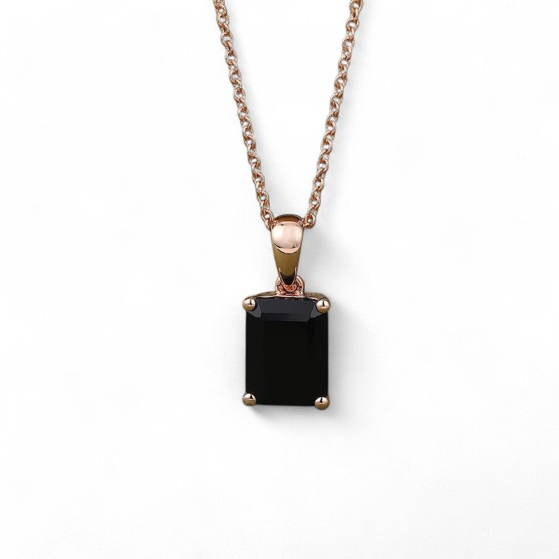 Emerald-cut black onyx pendant with 6x8mm centerpiece, featuring a 0.4-carat moissanite accent in a secure open basket setting, symbolizing strength and elegance