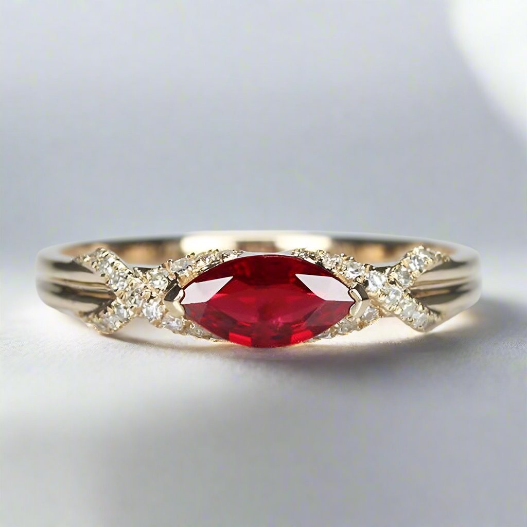 a stunning design featuring a 0.45ct marquise-cut ruby set horizontally on a sleek 14K gold band, available in rose, white, or yellow gold. The ring is accented with 0.10ct of sparkling moissanite side stones, showcasing timeless elegance and modern style. Perfect for stacking or as a standalone statement piece.